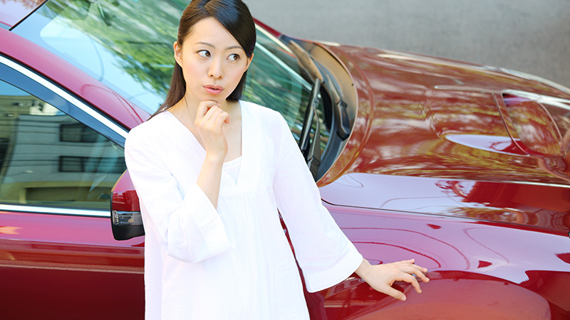 新車にコーティングが必要か迷う女性