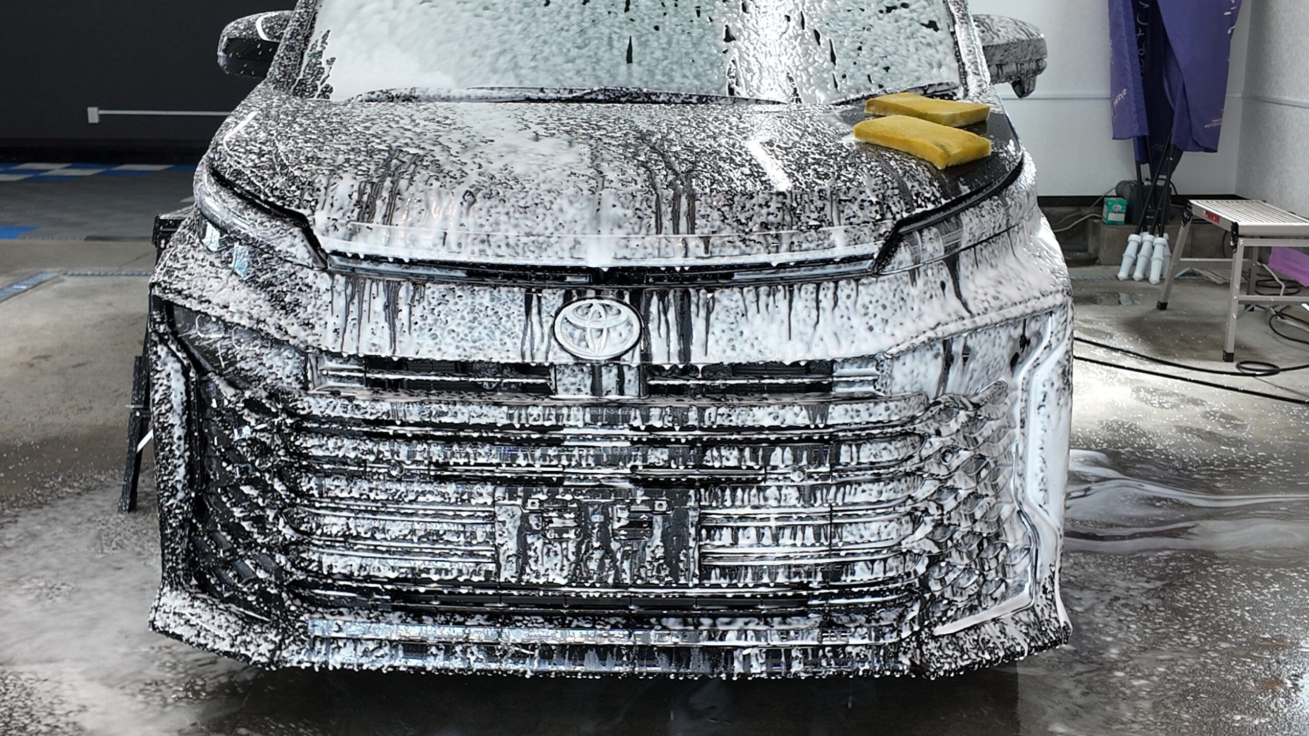 新車トヨタ ヴォクシーを純水手洗い洗車で泡洗浄している様子